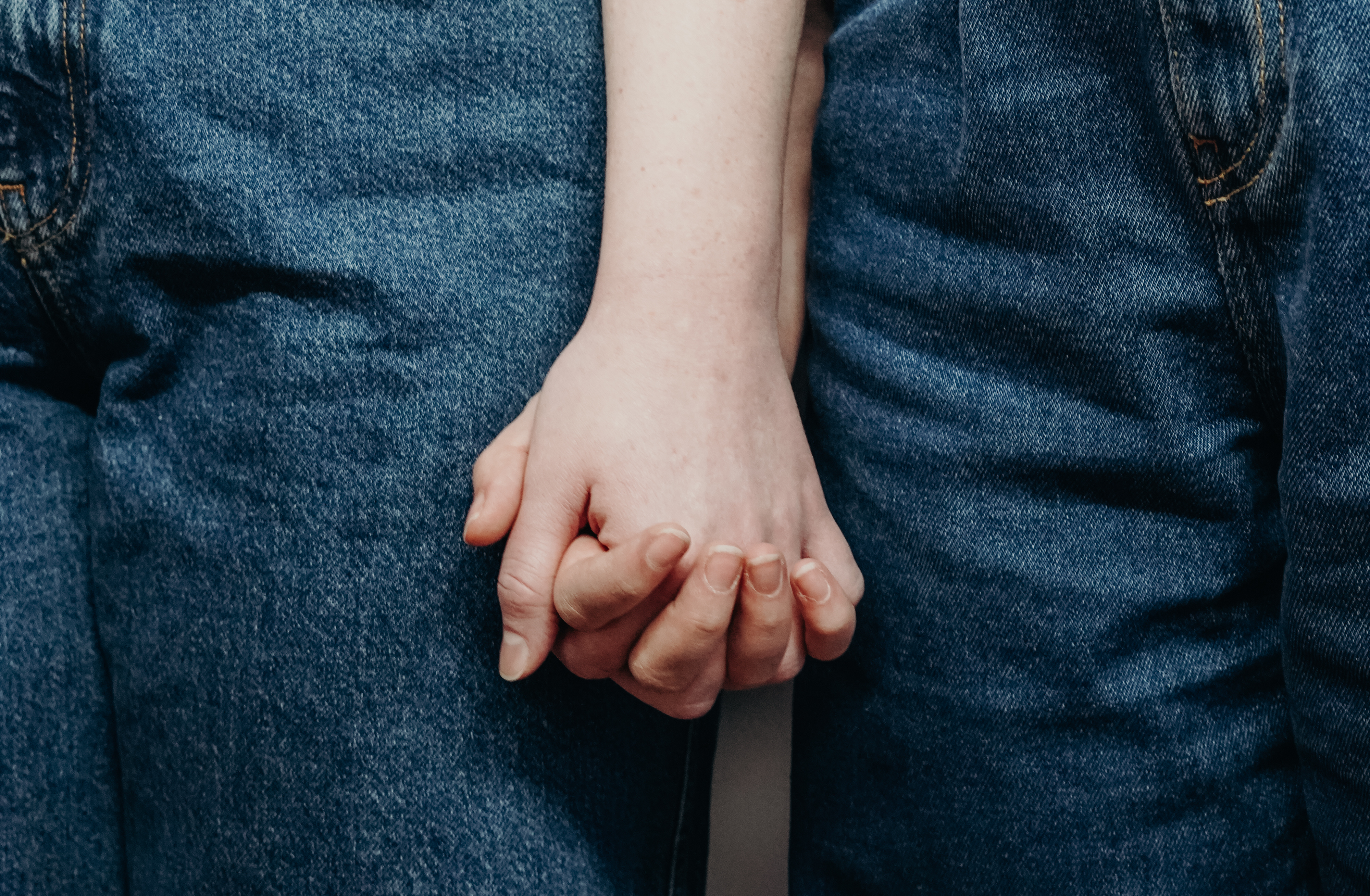 persons-wearing-denim-jeans-while-holding-hands-3693861