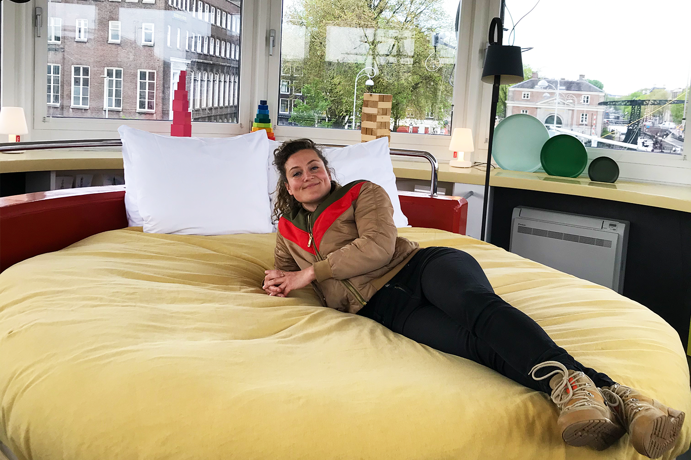Nienke ligt op een bed in een brugwachtershuisje in Amsterdam
