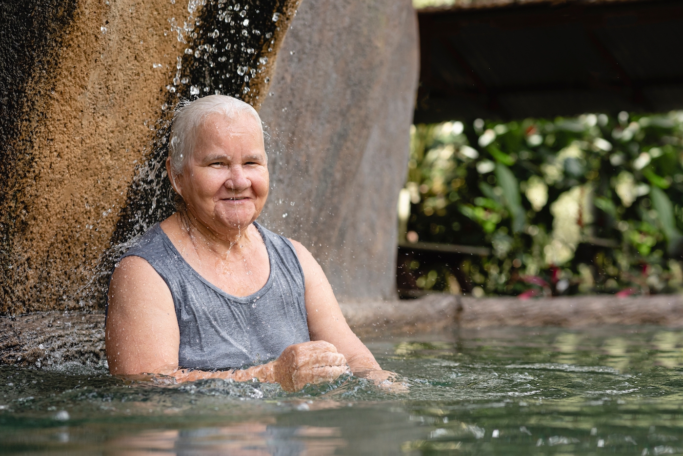 Oude vrouw baddert in heetwaterbron in Costa Rica