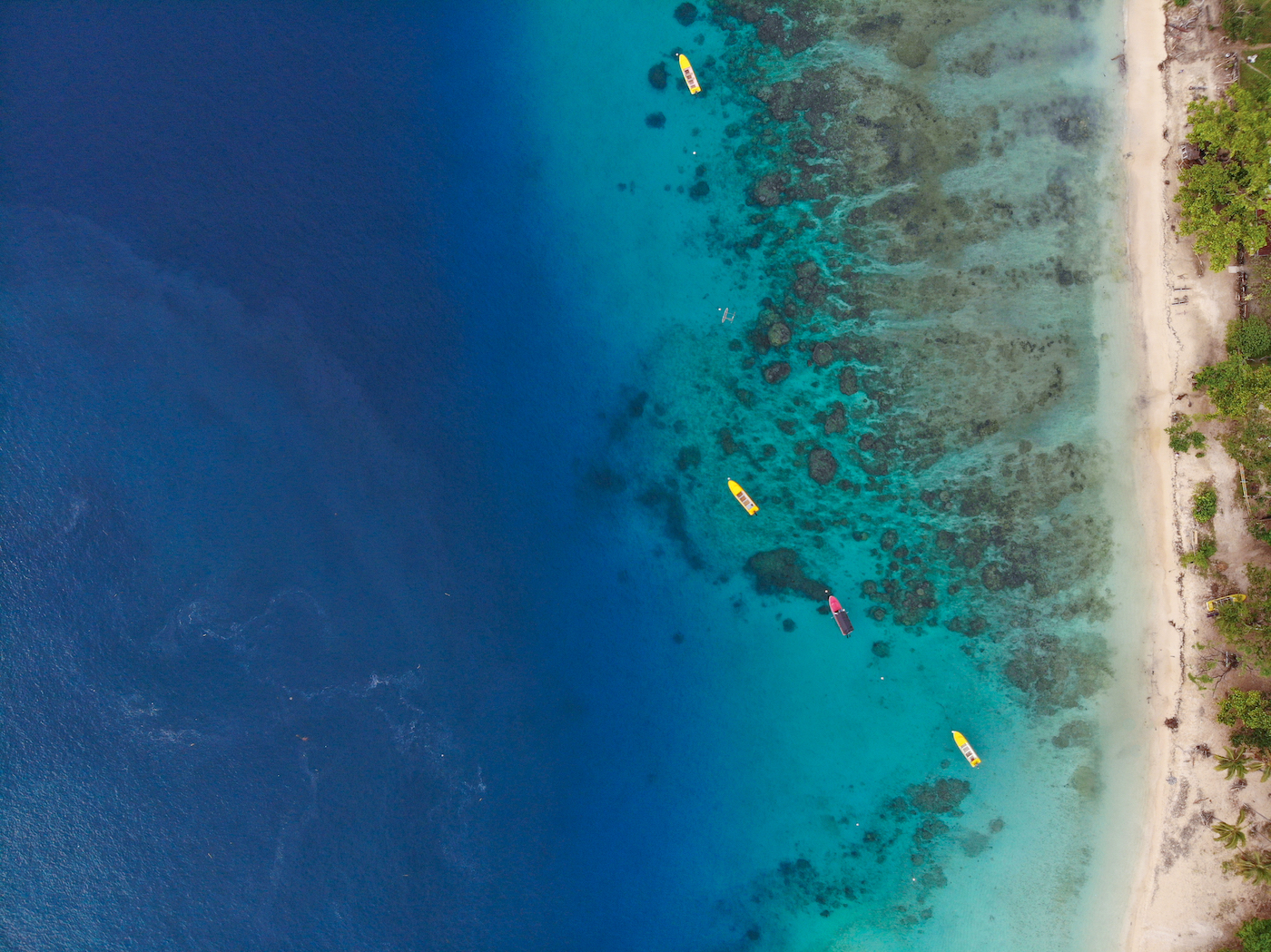 Koraalrif van boven gezien met strand en helder blauw water in Vanuatu