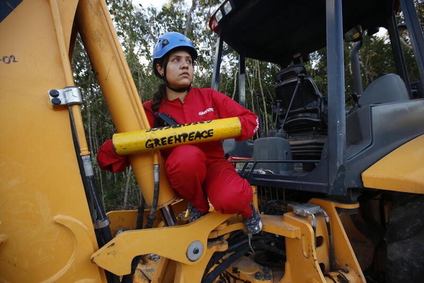 Demonstrant van GreenPeace bindt zich vast aan een bulldozer tijdens een protest in maart 2022