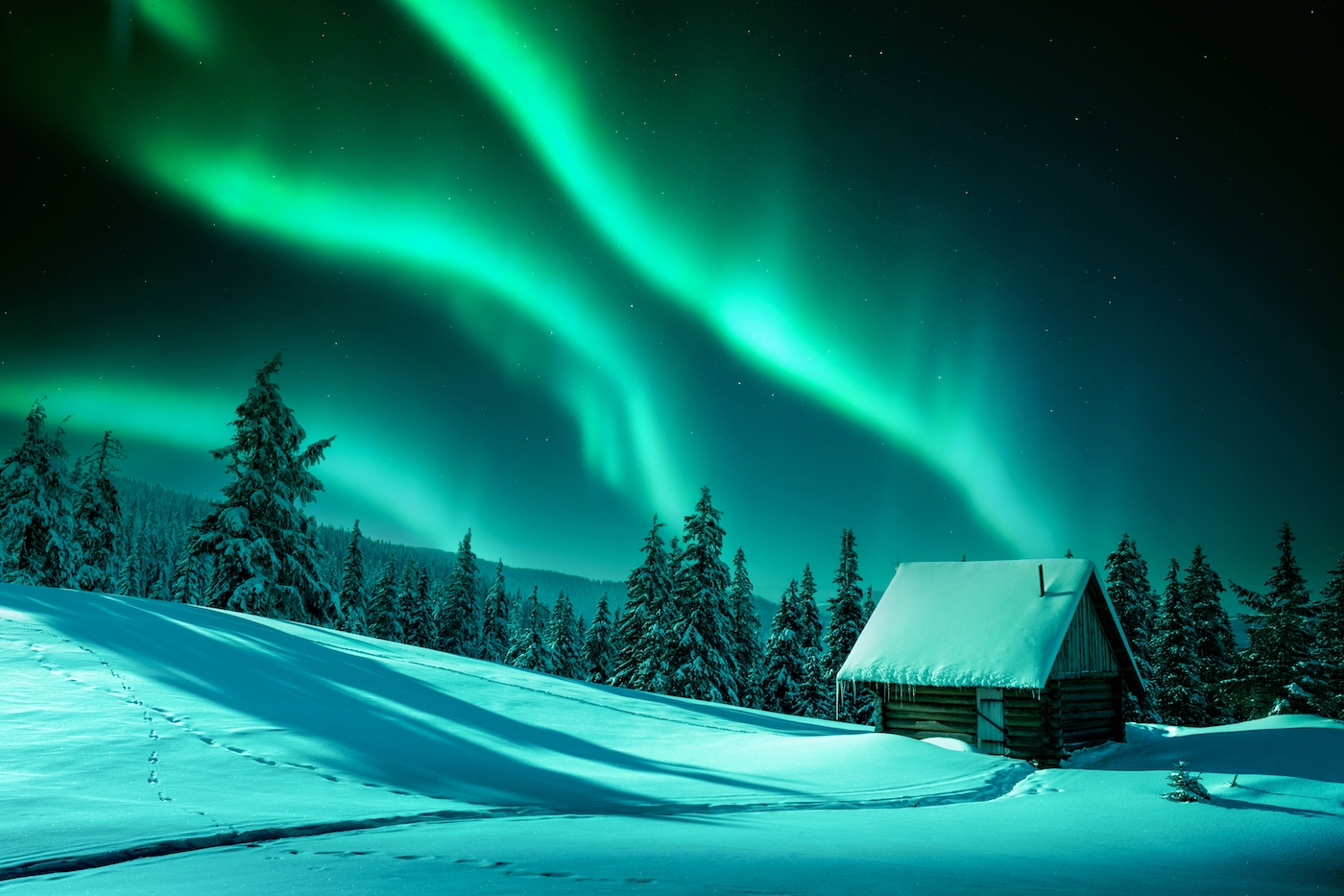 Een romantisch huisje met besneeuwd dak in Scandinavië en het noorderlicht op de achtergrond